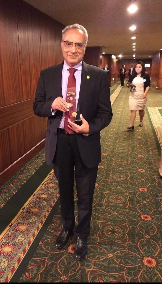 Dr Wafik Moustafa holding a Plaque of Appreciation